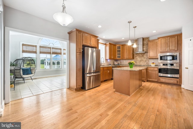 301 Nottingham Ln, Queenstown, MD 21658 - kitchen with appliances with stainless steel finishes, wall chimney exhaust hood, brown cabinetry, light wood-style flooring, and recessed lighting