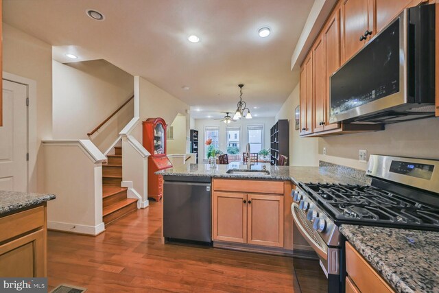 311 I St SE, Washington, DC 20003 - kitchen featuring appliances with stainless steel finishes, a sink, a peninsula, dark wood-style floors, and stone countertops