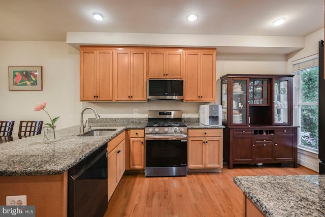 311 I St SE, Washington, DC 20003 - kitchen with stainless steel appliances, a sink, light wood-type flooring, dark stone counters, and recessed lighting