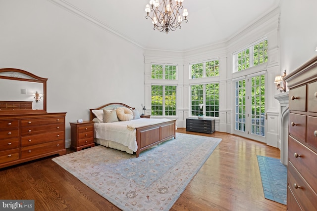 601 Utterback Store Rd, Great Falls, VA 22066 - bedroom featuring a towering ceiling, a chandelier, access to exterior, and wood finished floors