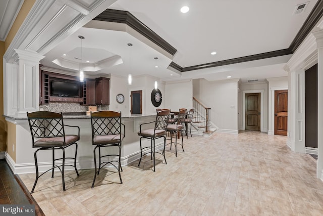 601 Utterback Store Rd, Great Falls, VA 22066 - kitchen with a kitchen bar, ornamental molding, decorative backsplash, decorative columns, and light wood-style flooring