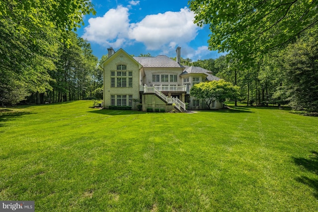 601 Utterback Store Rd, Great Falls, VA 22066 - back of property featuring stairs, a chimney, a yard, and a deck