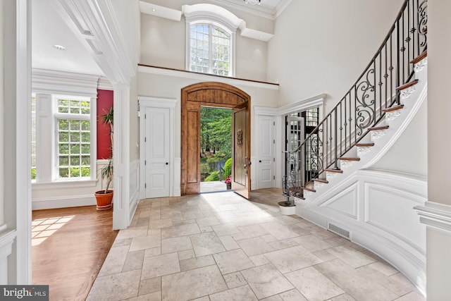 601 Utterback Store Rd, Great Falls, VA 22066 - foyer entrance featuring plenty of natural light, stone tile floors, stairs, ornamental molding, and a high ceiling