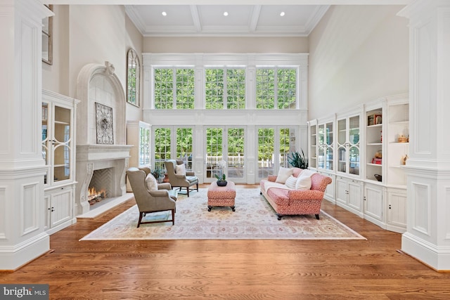 601 Utterback Store Rd, Great Falls, VA 22066 - living room with a high ceiling, ornate columns, a high end fireplace, wood finished floors, and coffered ceiling