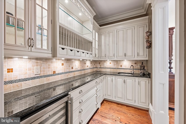 601 Utterback Store Rd, Great Falls, VA 22066 - kitchen with ornamental molding, beverage cooler, a sink, dark stone countertops, and glass insert cabinets