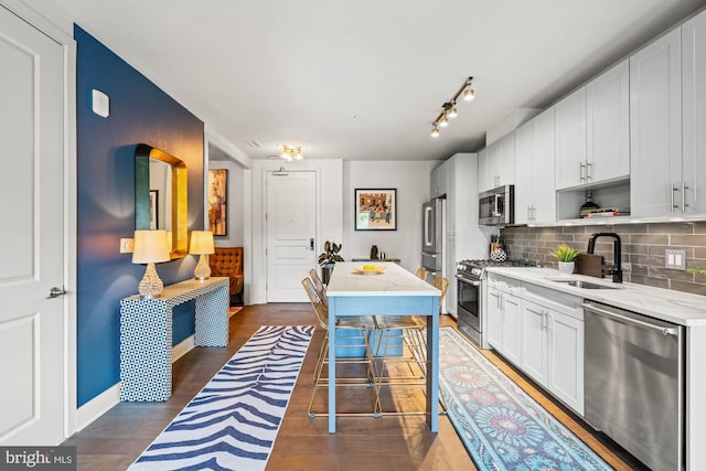 6803 Cameron Dr NW Unit 105, Washington, DC 20012 - kitchen featuring appliances with stainless steel finishes, a sink, decorative backsplash, and light stone countertops