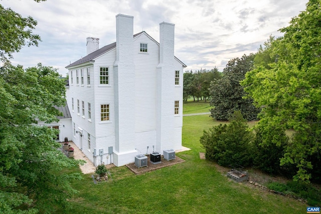 3276 Buckingham Springs Rd, Dillwyn, VA 23936 - view of side of home with a chimney, central AC unit, an attached garage, and a yard