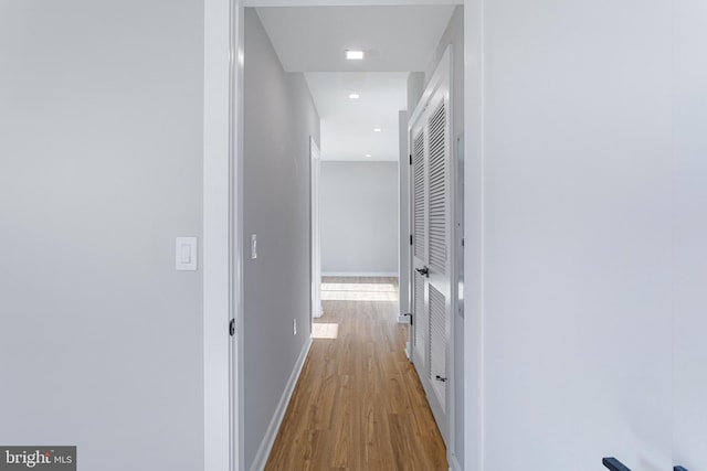 hall with wood finished floors, baseboards, and recessed lighting