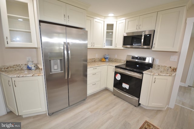 204 W Chew Ave, Saint Michaels, MD 21663 - kitchen featuring stainless steel appliances, light wood-style floors, glass insert cabinets, and light stone countertops
