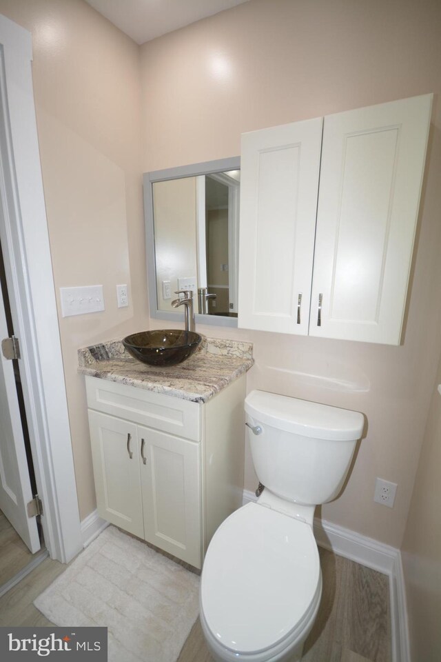 204 W Chew Ave, Saint Michaels, MD 21663 - bathroom featuring vanity, toilet, baseboards, and wood finished floors