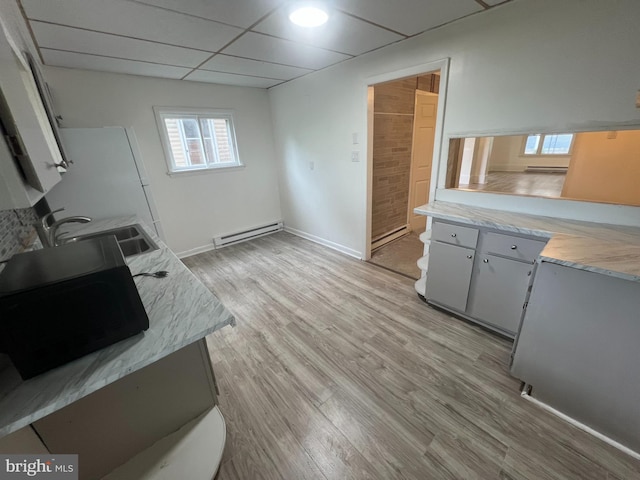 19 S Gold St, Shamokin, PA 17872 - kitchen with baseboard heating, a sink, light wood-type flooring, light countertops, and a paneled ceiling
