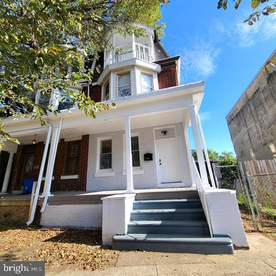 view of front of home with brick siding and a porch