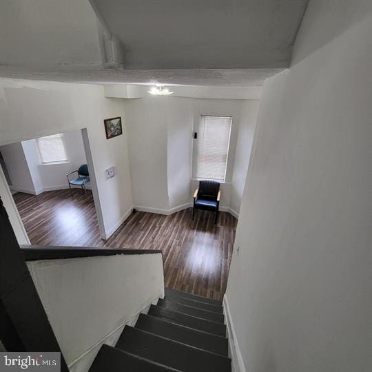 stairway featuring wood finished floors and baseboards