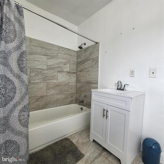 bathroom featuring shower / bath combo with shower curtain and vanity