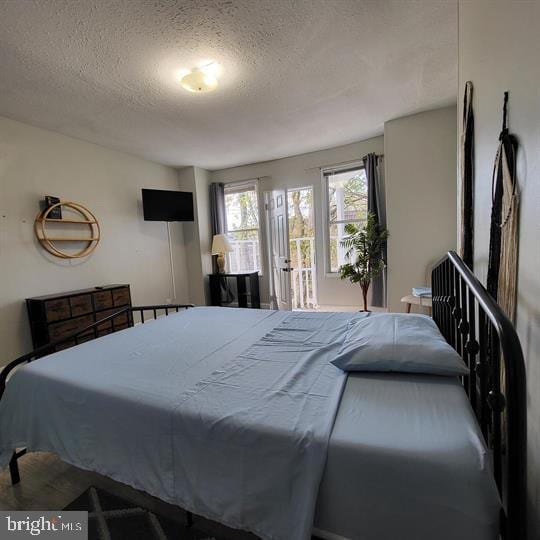 bedroom featuring a textured ceiling and access to outside