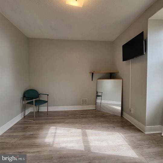 empty room with wood finished floors and baseboards