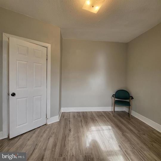 empty room with wood finished floors and baseboards