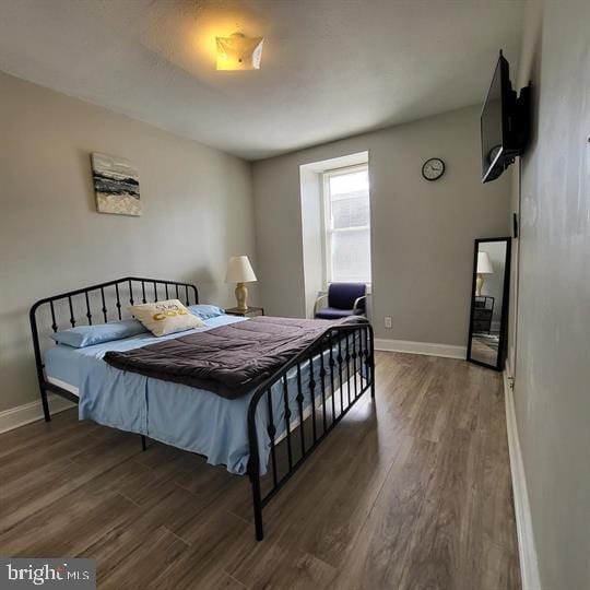 bedroom featuring wood finished floors and baseboards