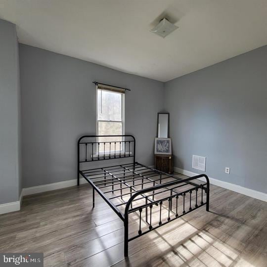 bedroom featuring wood finished floors and baseboards