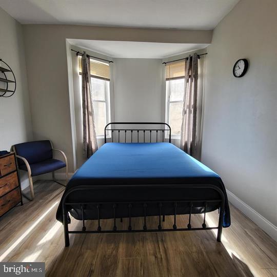 bedroom featuring wood finished floors and baseboards