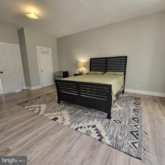 bedroom with wood finished floors and baseboards