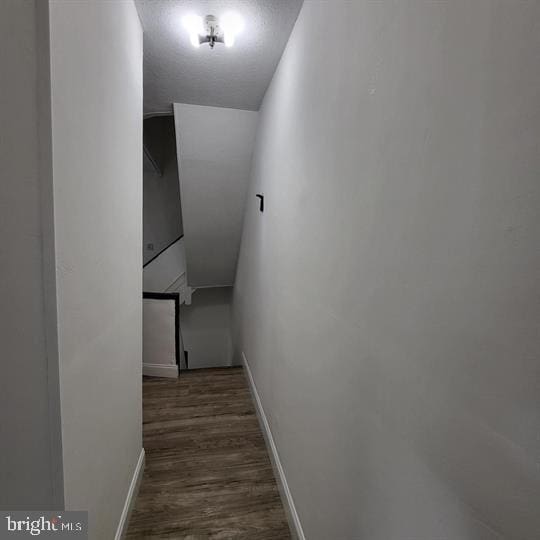 hallway with dark wood-style flooring and baseboards