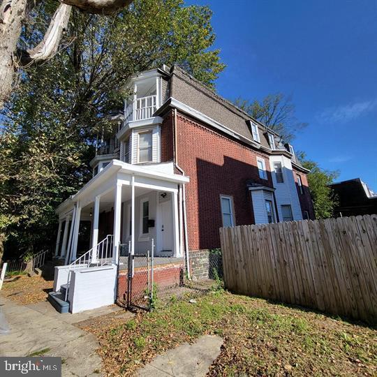 view of front of house featuring brick siding and a porch