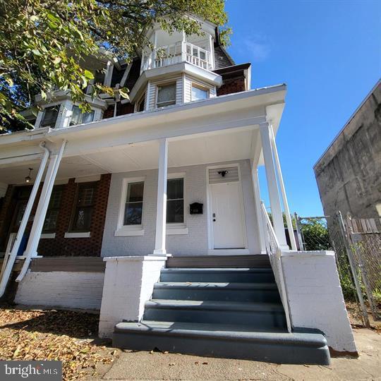 view of front facade featuring covered porch and brick siding
