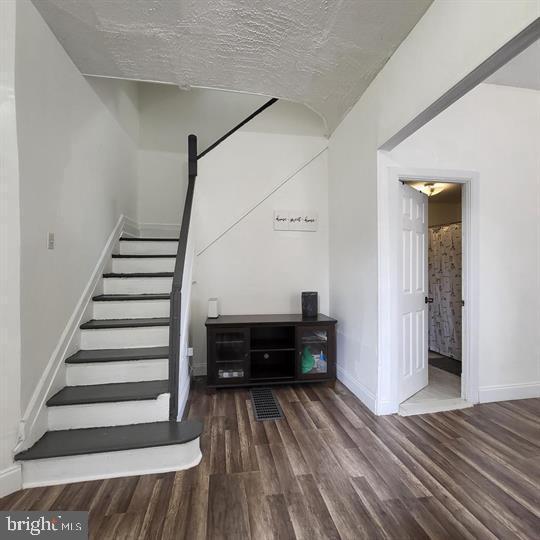stairway with wood finished floors and baseboards