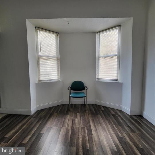 spare room featuring dark wood finished floors and baseboards