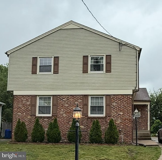 view of front of property with a front lawn and brick siding