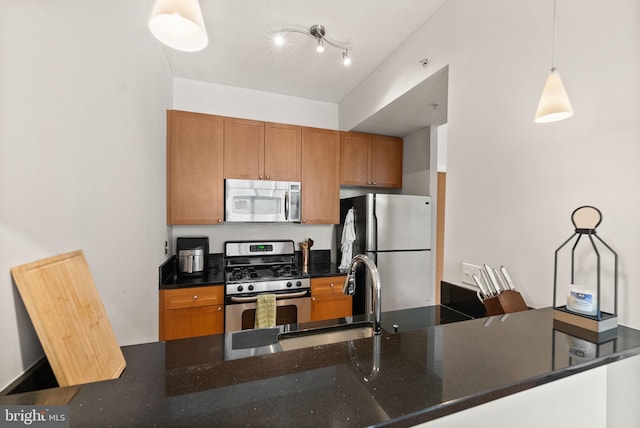 2120 Vermont Ave NW Unit 411, Washington, DC 20001 - kitchen featuring stainless steel appliances, a sink, brown cabinets, decorative light fixtures, and dark stone countertops