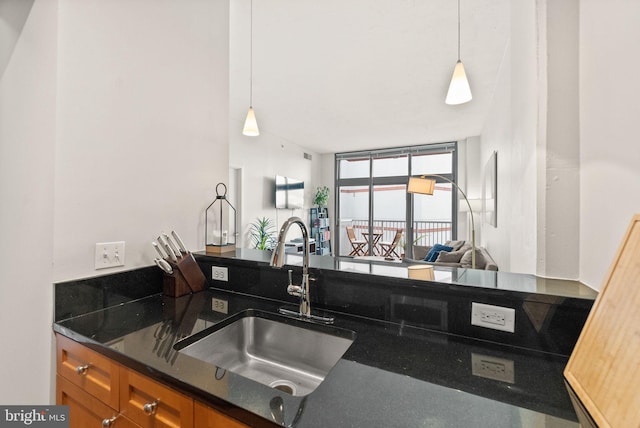 2120 Vermont Ave NW Unit 411, Washington, DC 20001 - kitchen with a sink, brown cabinets, dark stone countertops, and hanging light fixtures