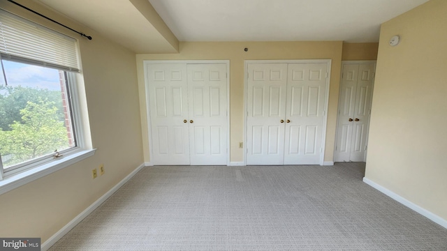 610 N W St Unit 401, Alexandria, VA 22314 - unfurnished bedroom with multiple closets, multiple windows, carpet flooring, and baseboards
