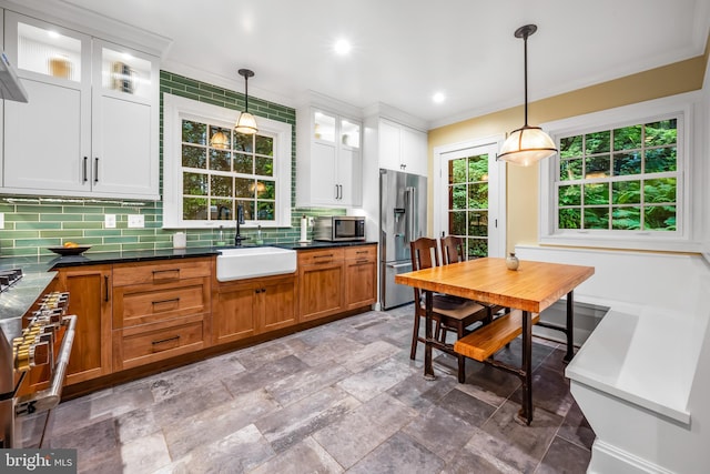 109 Deepdene Rd, Baltimore, MD 21210 - kitchen featuring a sink, premium appliances, decorative backsplash, glass insert cabinets, and pendant lighting
