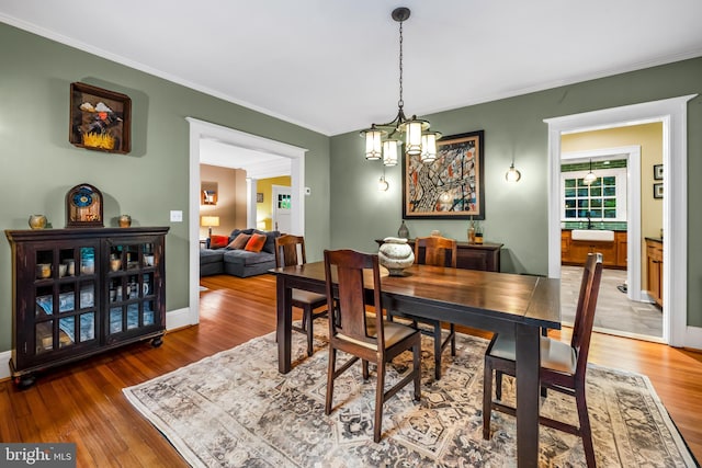 109 Deepdene Rd, Baltimore, MD 21210 - dining area featuring wood finished floors, crown molding, a chandelier, and baseboards