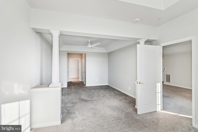 carpeted spare room with a ceiling fan, decorative columns, baseboards, and a smoke detector