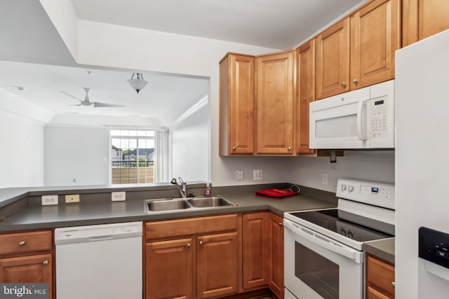 kitchen featuring white appliances, a sink, dark countertops, a peninsula, and ceiling fan