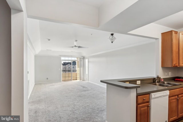 kitchen featuring dishwasher, dark countertops, open floor plan, a sink, and light carpet