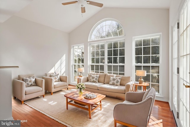 living area featuring a ceiling fan, hardwood / wood-style floors, and high vaulted ceiling
