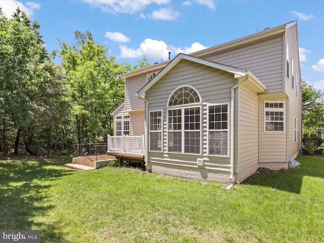 rear view of property with a deck and a yard