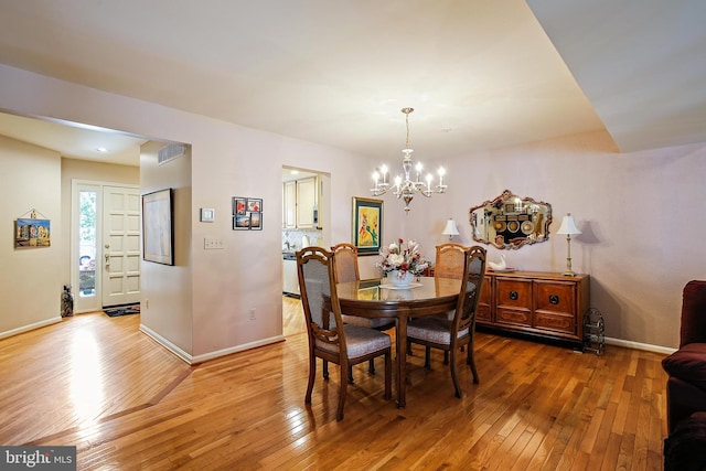 106 River Oaks, Baltimore, MD 21208 - dining room with a chandelier, light wood finished floors, and baseboards