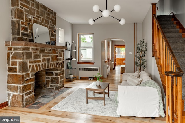 308 Cherry St, Columbia, PA 17512 - living area featuring radiator heating unit, arched walkways, wood finished floors, and a chandelier