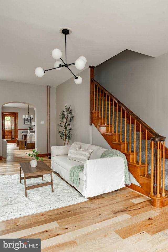 308 Cherry St, Columbia, PA 17512 - living area with arched walkways, a chandelier, wood finished floors, and stairs