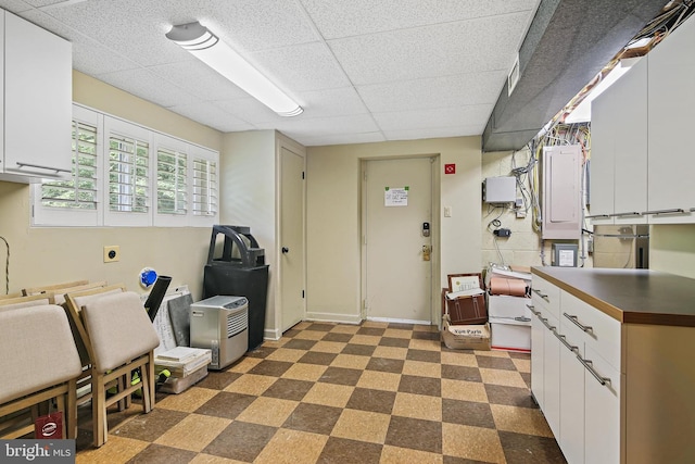 3503 Arborwood Ct, Baltimore, MD 21208 - kitchen with dark floors, electric panel, a drop ceiling, and white cabinets