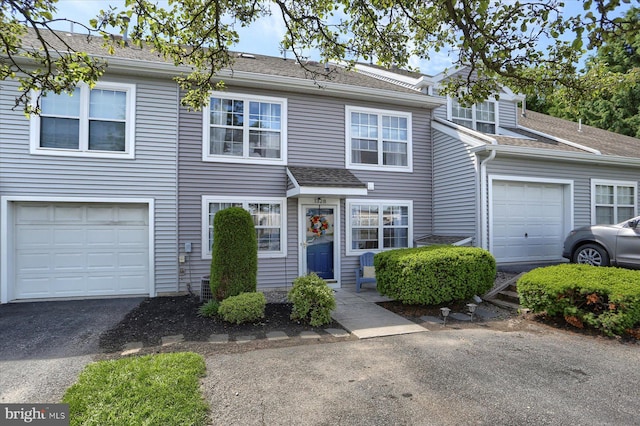 1328 N W St, Carlisle, PA 17013 - view of front of property featuring a garage, a shingled roof, asphalt driveway, and central AC unit