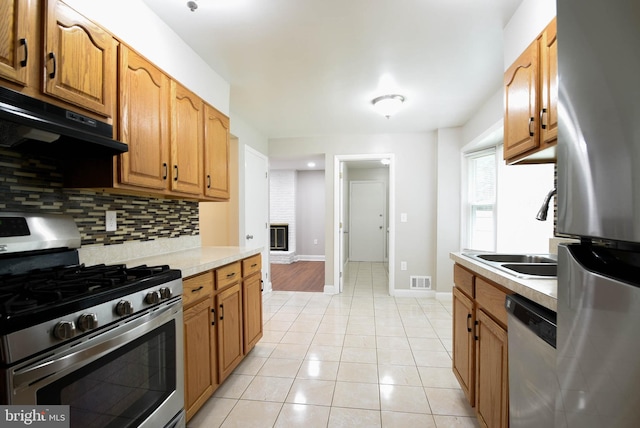 8514 Magnolia Dr, Lanham, MD 20706 - kitchen featuring stainless steel appliances, a sink, light countertops, ventilation hood, and backsplash