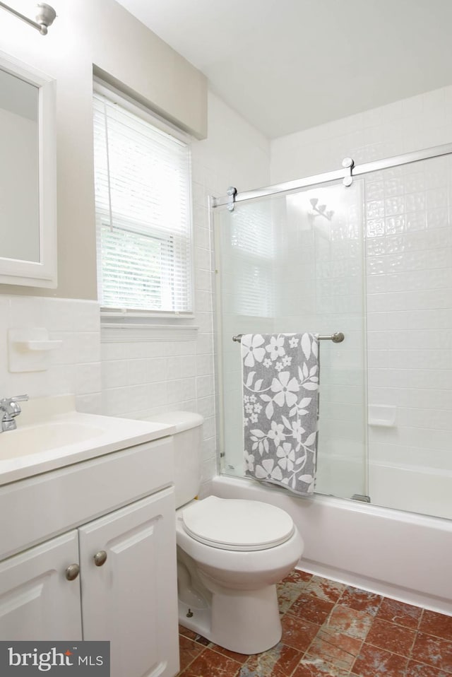 8514 Magnolia Dr, Lanham, MD 20706 - bathroom with vanity, shower / bath combination with glass door, toilet, and tile walls