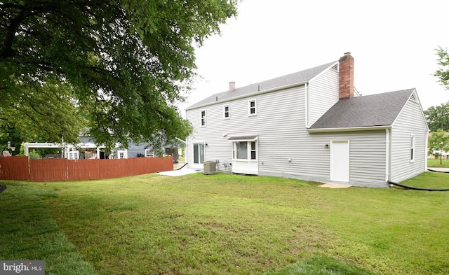 8514 Magnolia Dr, Lanham, MD 20706 - rear view of house with a chimney, a shingled roof, and central AC unit