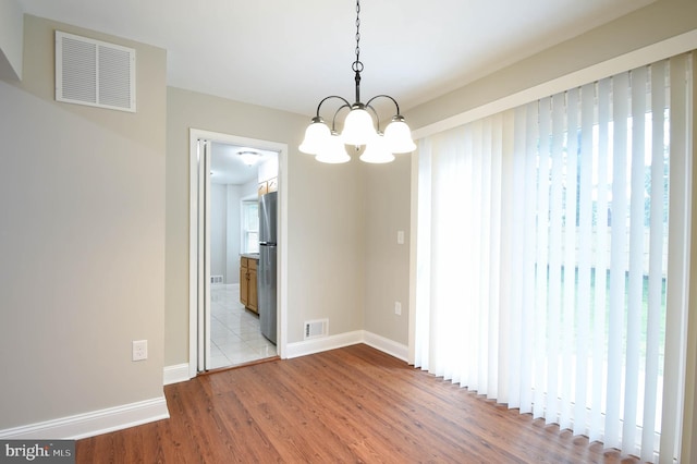 8514 Magnolia Dr, Lanham, MD 20706 - unfurnished room with wood finished floors, a chandelier, and baseboards